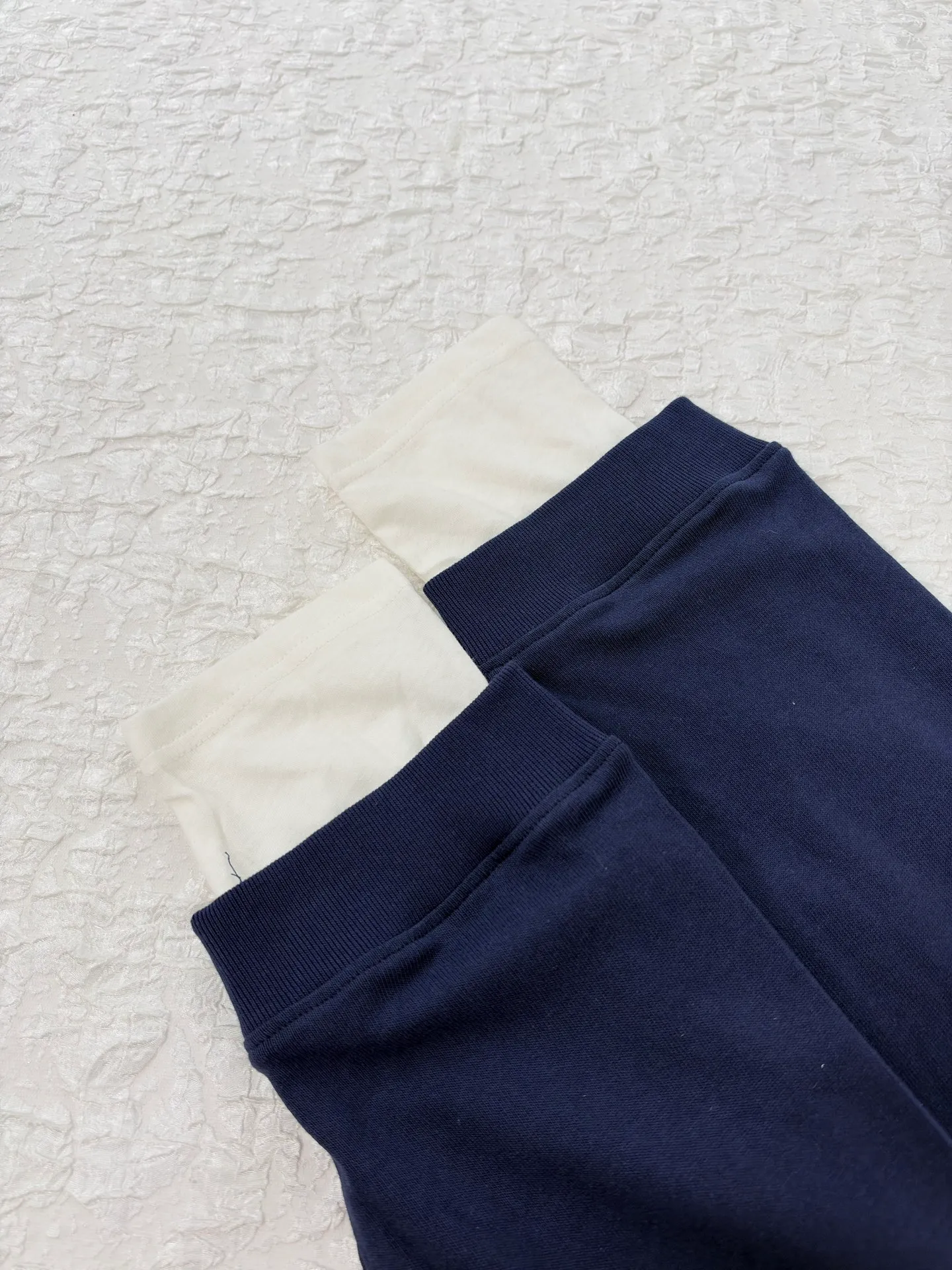 Acne Studio letter logo embroidered fake two-piece deconstructed long-sleeved T-shirt. Made of 100% cotton knitted plain fabric. The garment is pre-shrunk and washed to effectively reduce washing shrinkage. The version adopts dropped shoulder sleeves + loose box cut, the round neck is equipped with a rib collar, and the binding strip is used under the collar for reinforcement. The front chest uses high-density computer embroidery technology to present the brand logo. Visually, the inner and outer layers are designed with contrasting color splicing. The hem and cuffs are double-layered fake two-piece stacking. The sewing adopts flat seam + overlock technology. The lines are even and dense, and the overall relaxed silhouette takes into account practical wearability and layering effect. It can be worn alone or layered. Size：S/M/L/XL